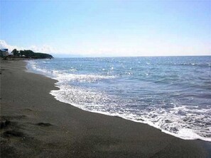 A beach with a sandy shore and waves gently lapping at the edge.