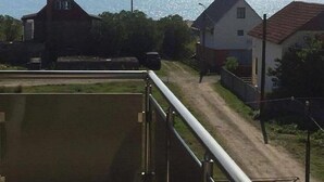 A balcony with a view of the sea and houses.