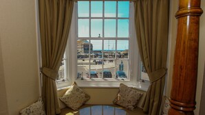 A bay window with a view of a busy street and buildings.