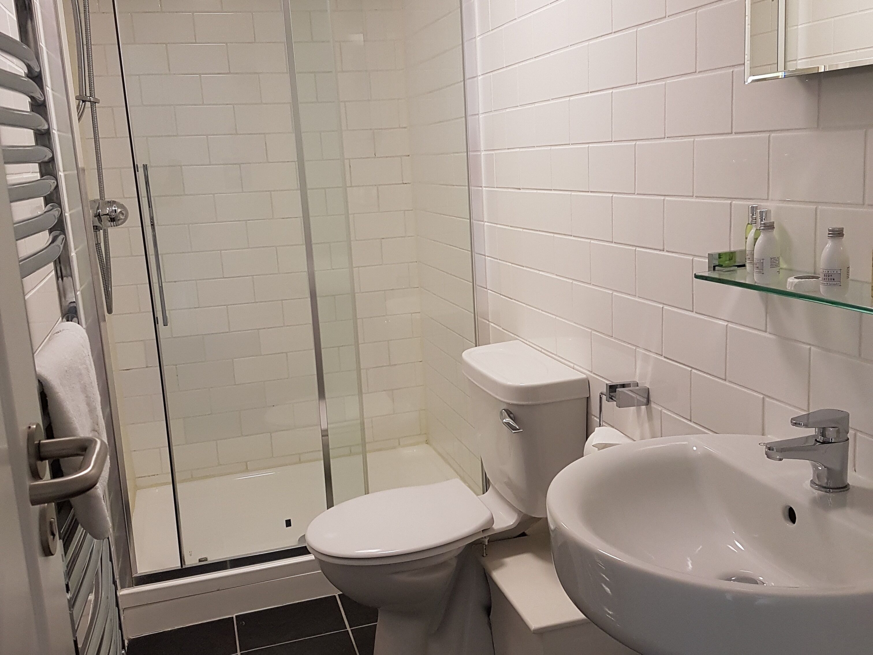 Et badeværelse med brusekabine, toilet og vask.