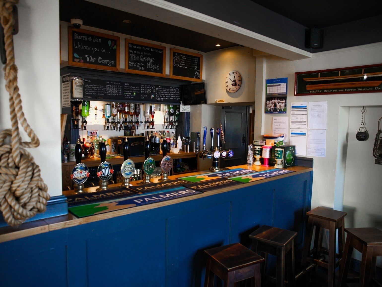 A bar area with a counter displaying various beer taps and a chalkboard menu.
