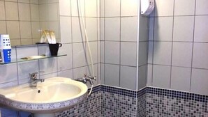 A bathroom with a sink, mirror, shower, and tiled walls. - Summer Kenting B&B (Hengchun)
