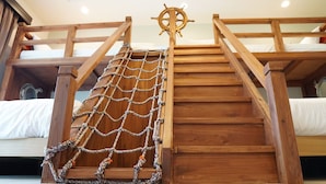 A wooden bunk bed with a rope ladder and a ship's wheel decoration. - T&T Vacation Rentals (Onna)