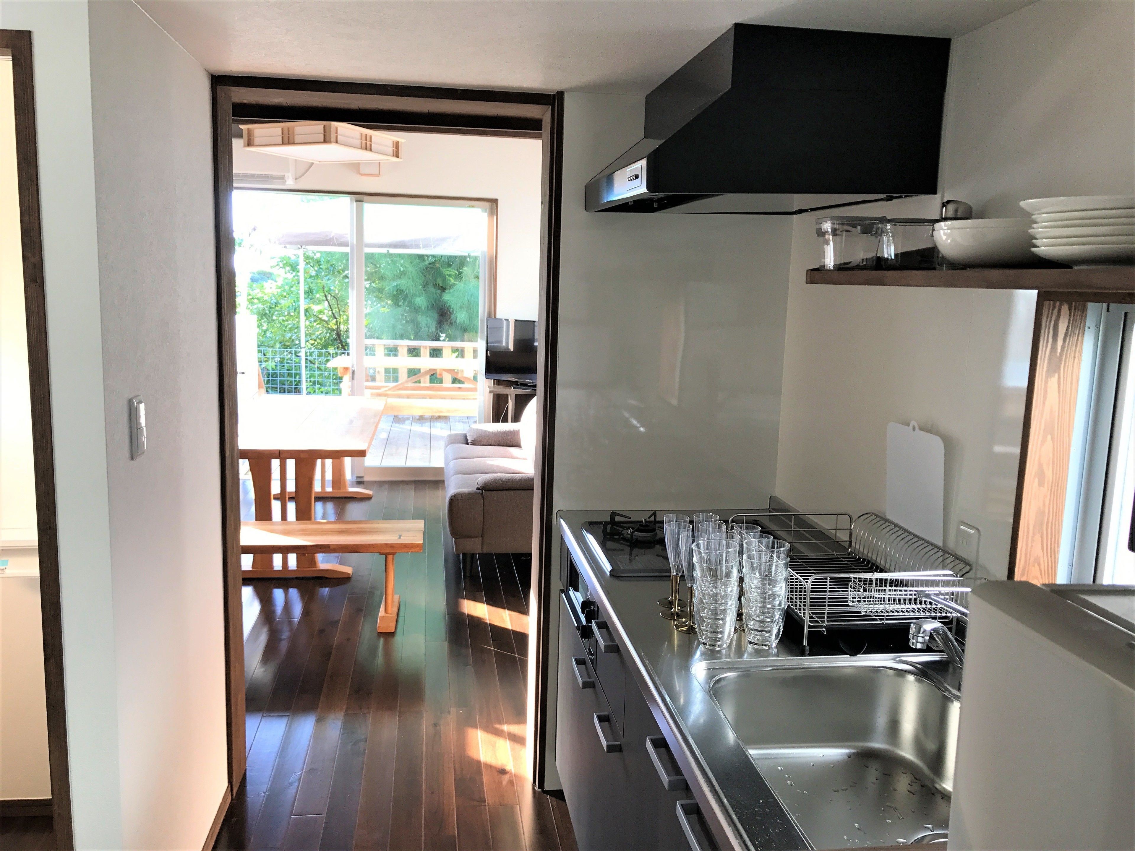 A modern kitchen with a built-in stove, a sink, and a dining area with a table and chairs.