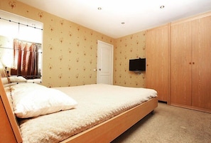 Enjoy a restful stay in this cozy room featuring a single bed, TV, and wardrobe.