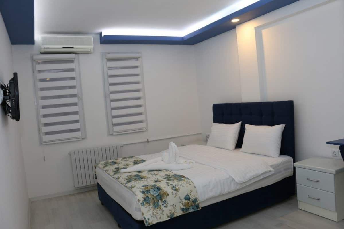 Ein Schlafzimmer mit einem Bett, Nachttischen und einem Heizkörper.