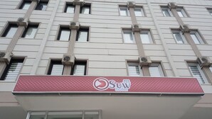 A building with multiple windows and air conditioning units. There is a sign for 'Sun Hotel' on the facade. - Suw Hotel (Atakum)