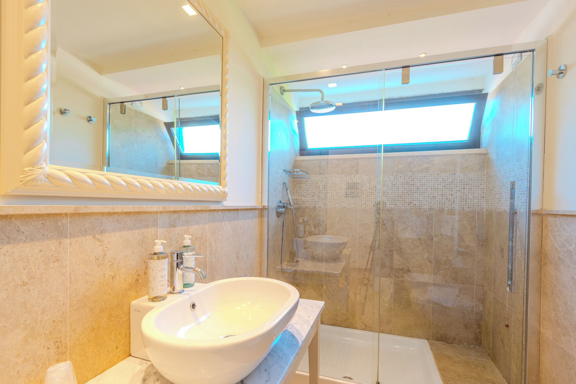 A bathroom with a large mirror, a sink, a shower, and a bathtub.