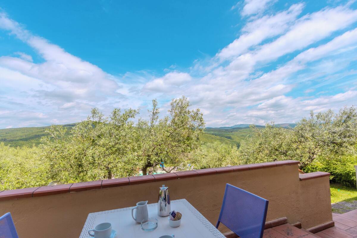 Une table offrant une vue sur des collines verdoyantes et un ciel dégagé.