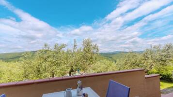 Ein Tisch mit Blick auf grüne Hügel und einen klaren Himmel.
