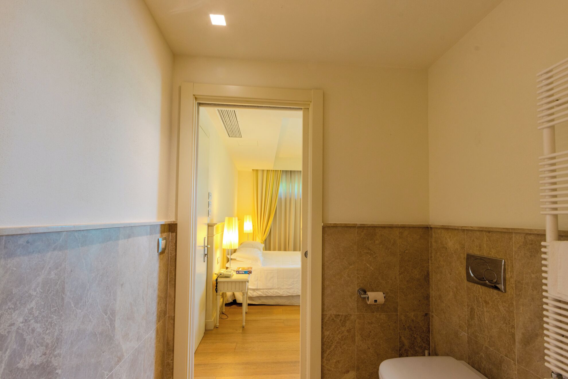 Un baño de hotel con ducha, inodoro y espejo.