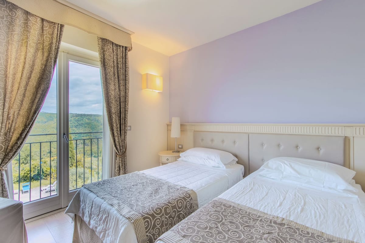 Une chambre d’hôtel avec deux lits, un balcon et une vue sur le paysage.