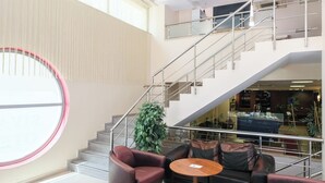 A modern lobby with a staircase, leather seating, and a large window. - Siyav Hotel (Ankara)