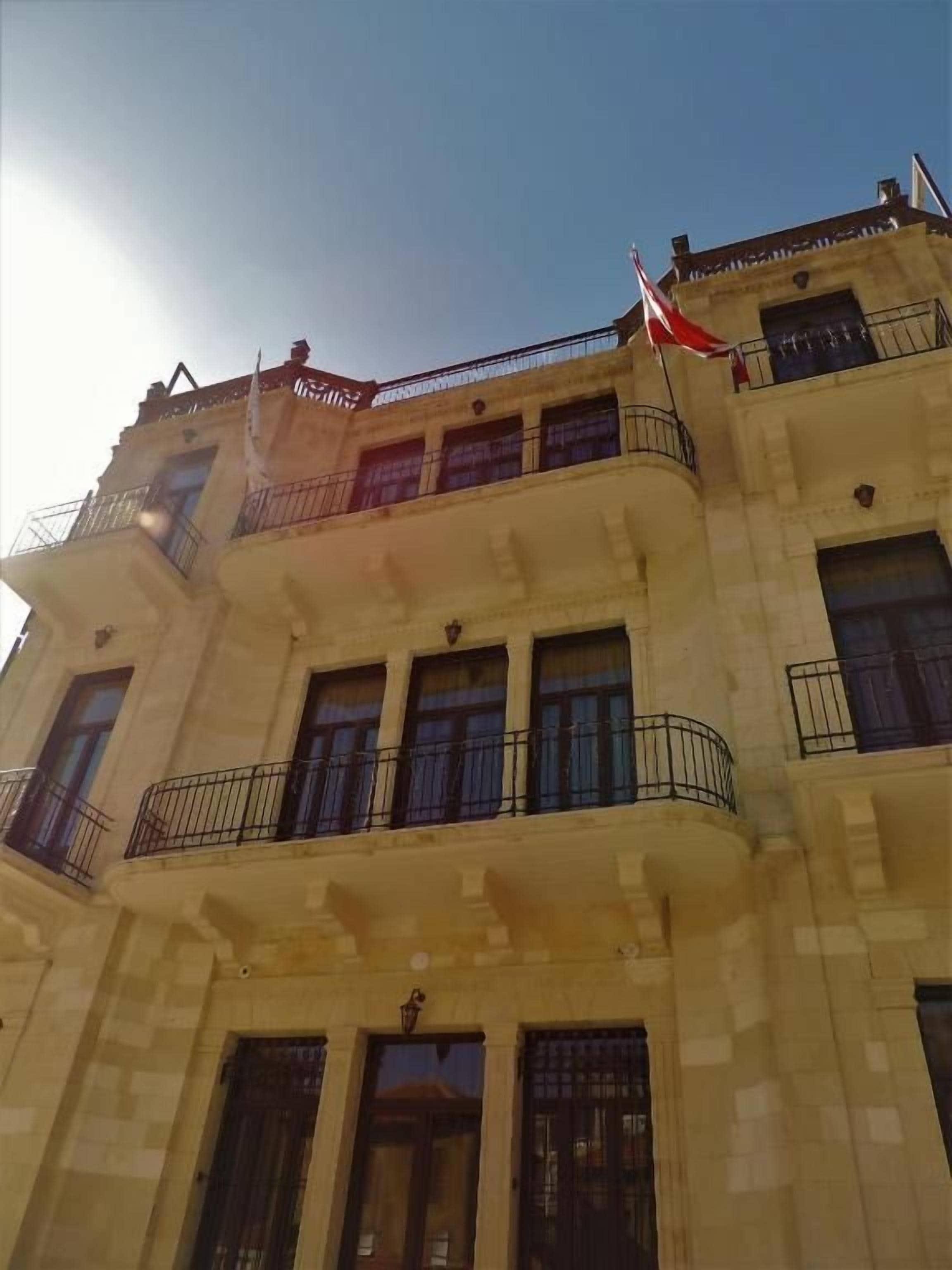 Un edificio de varios pisos con balcones y una bandera.