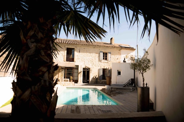 Una piscina al aire libre, sillones reclinables de piscina