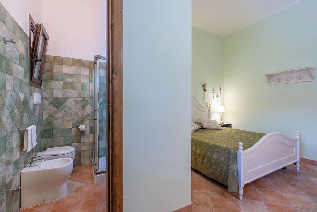 A bathroom with a shower, toilet, and bidet.