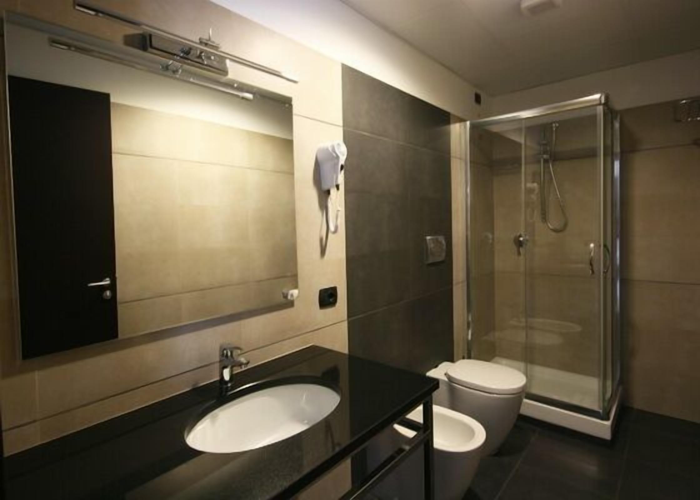 A modern bathroom with a sink, toilet, and glass-enclosed shower.