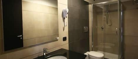 A modern bathroom with a sink, toilet, and glass-enclosed shower.