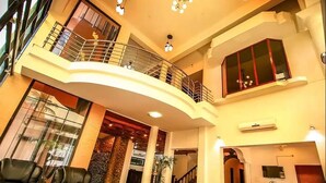 Un vaste espace de vie doté d’un balcon incurvé, de canapés en cuir et d’une grande fenêtre.