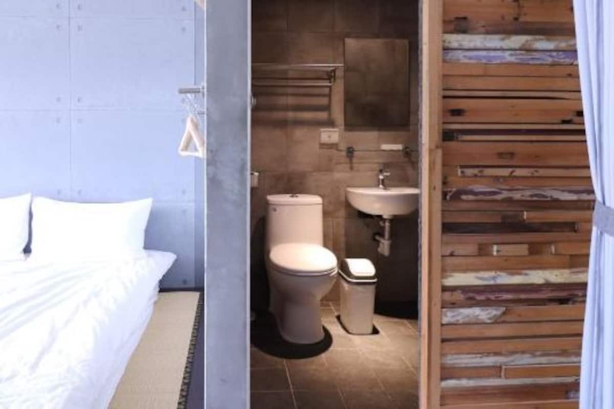 Une chambre à coucher avec un lit et une salle de bain avec des toilettes et un lavabo.
