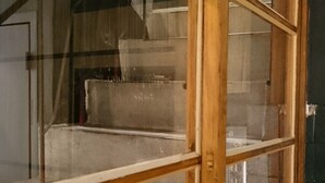 Una ventana con marco de madera y múltiples vidrios, con vista a una escalera.