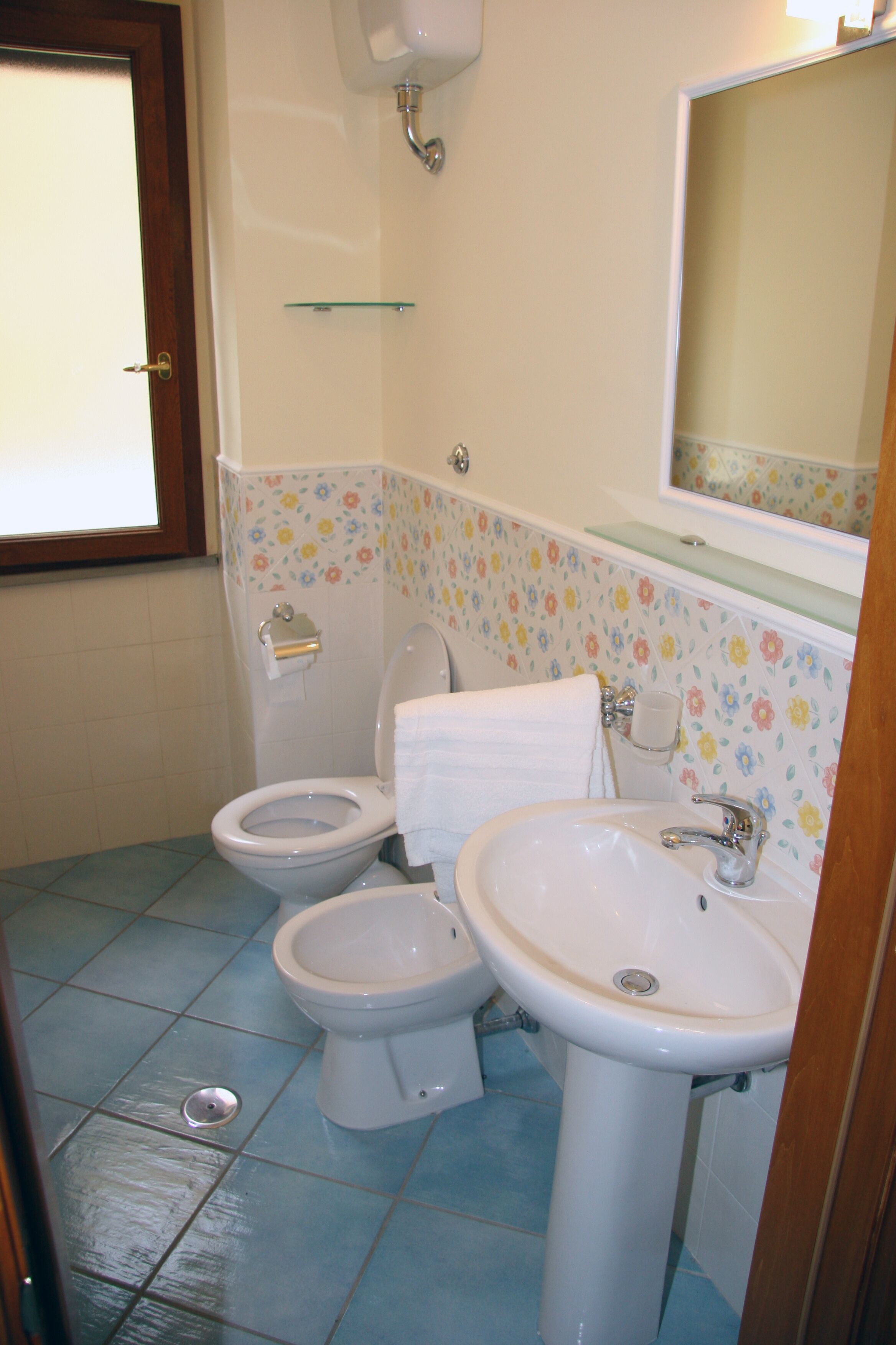 Une salle de bain équipée de toilettes, d’un bidet et d’un lavabo.