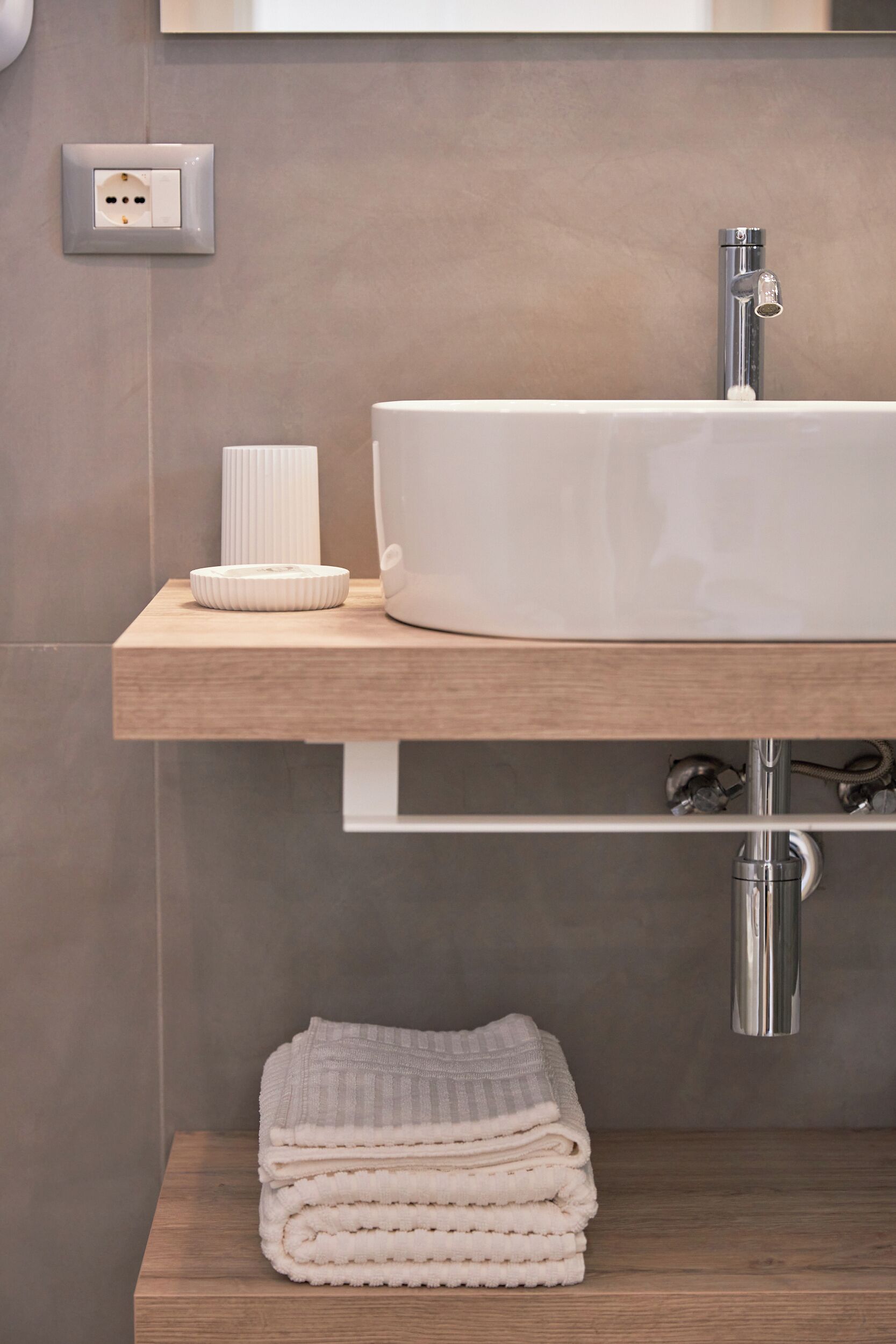 A bathroom with a white sink, a towel rack, and a mirror.