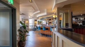 A bar area with a counter, stools, and a potted plant. - The Nines, Bangor Marina (Bangor)