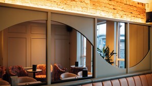 A restaurant with a brick wall, cushioned seating, and a view through a curved window. - The Nines, Bangor Marina (Bangor)