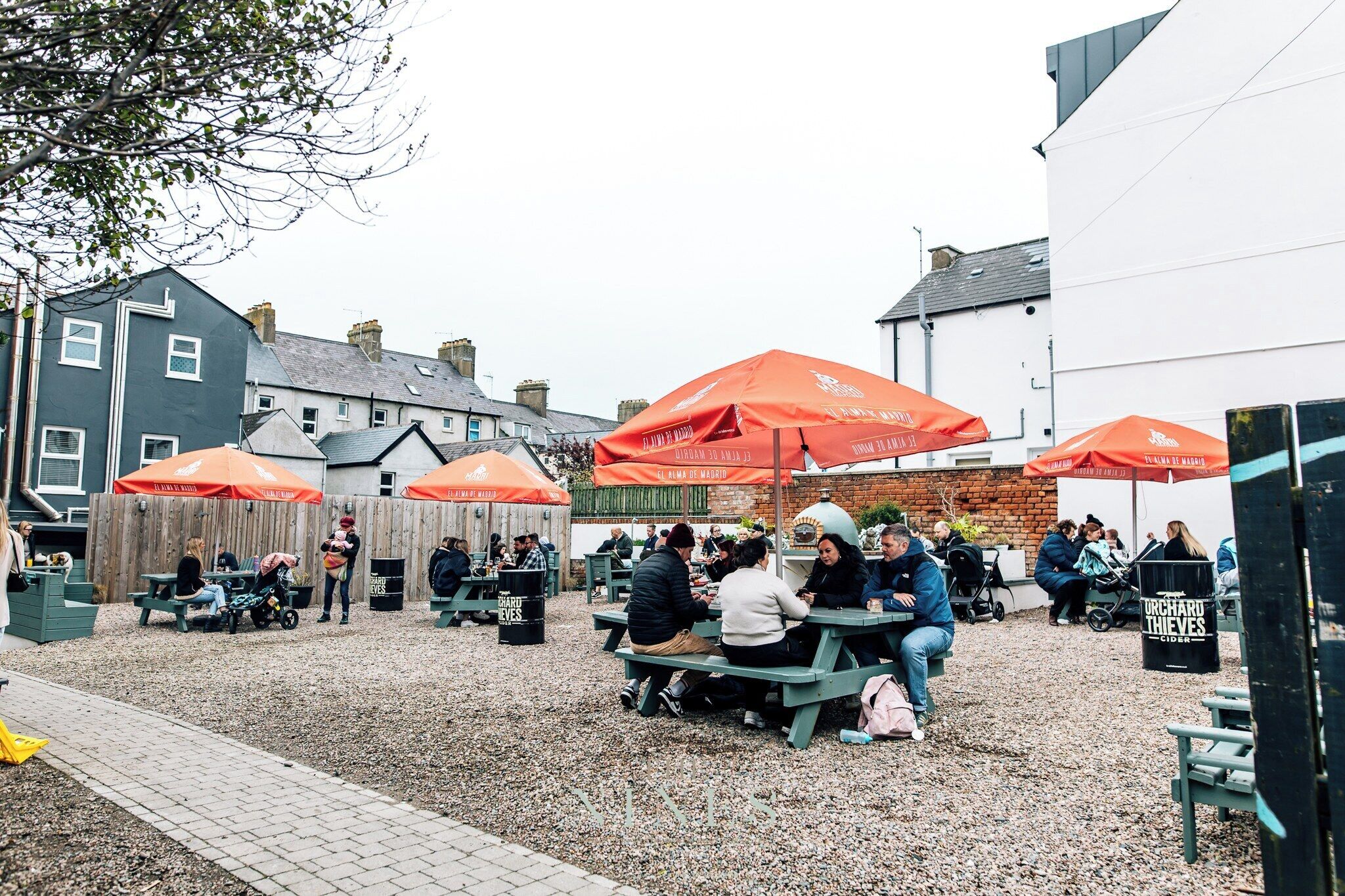 An outdoor seating area with tables and chairs, surrounded by buildings.