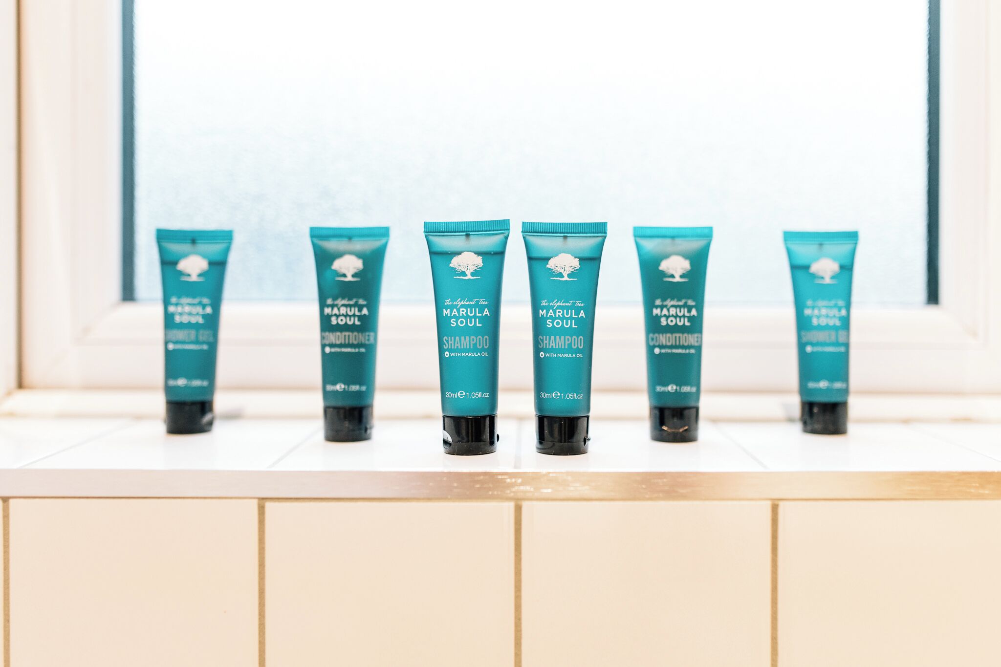 Seis productos Marula Soul sobre una superficie de baldosas blancas.