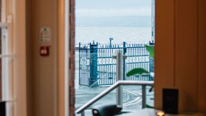 A restaurant interior with a view of the sea through a glass door. - The Nines, Bangor Marina (Bangor)