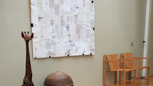 Quarto com escada de madeira, escultura de girafa e um mural de avisos com papéis.