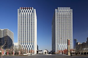 A modern building with a distinctive facade featuring vertical lines and a central archway. - Wanda Realm Yinchuan (Yinchuan)
