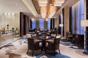 A modern hotel lobby with a central seating area, a bar, and a reception desk. - Wanda Realm Yinchuan (Yinchuan)