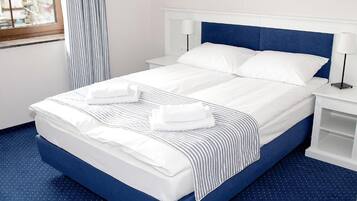 Tremannsrom, balkong, byutsikt | Skrivebord, strykejern/-brett og barnesenger