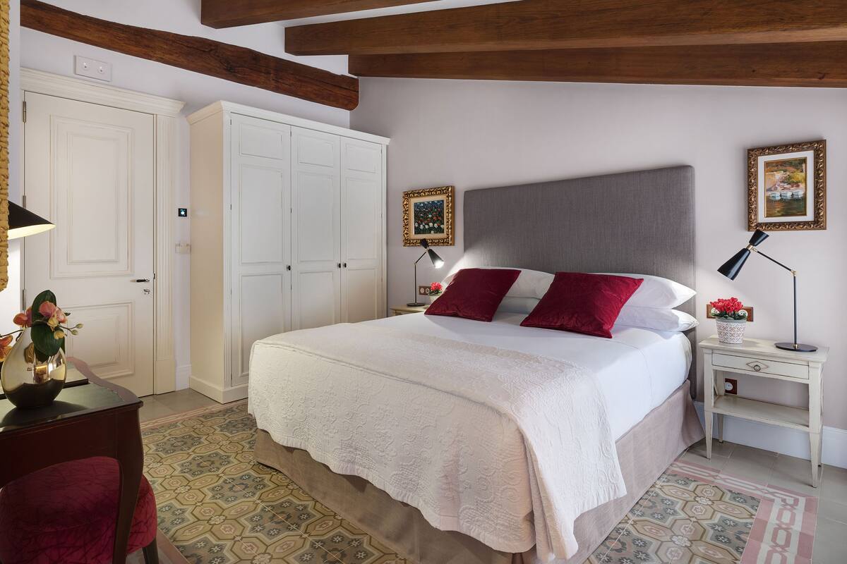 Ein Schlafzimmer mit einem Bett, einem weißen Kleiderschrank und einem Nachttisch mit Lampe.