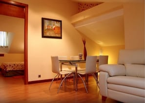 A dining area with a table and chairs, a sofa, and a painting on the wall. - Complejo El Carrascal (Munana)