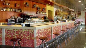 Zona de bar amb barra, tamborets i vitrina.