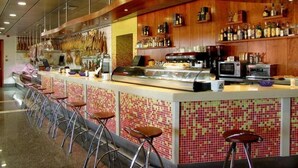 Zona de bar amb barra, tamborets i vitrina.