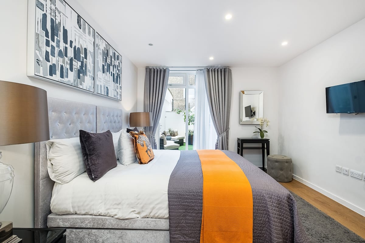 Une chambre moderne avec un grand lit, un téléviseur à écran plat et une vue sur l’extérieur.