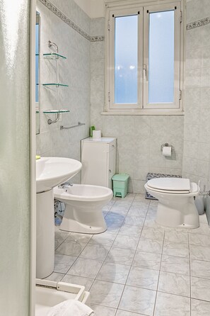 Un baño con dos lavamanos, inodoro y ducha.