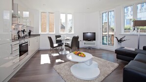 A modern living space with a kitchen, dining area, and seating area. - One Whites Row (London)