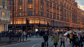 A historic building with ornate architecture and the name "HARRODS" prominently displayed.