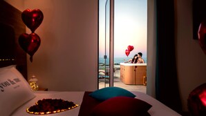 A hotel room with a bed, a view of the sea, and heart-shaped balloons. - You & Me Beach Hotel (Rimini)