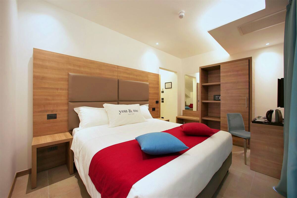 Ein modernes Hotelzimmer mit einem großen Bett, einem Schreibtisch und einem Stuhl.