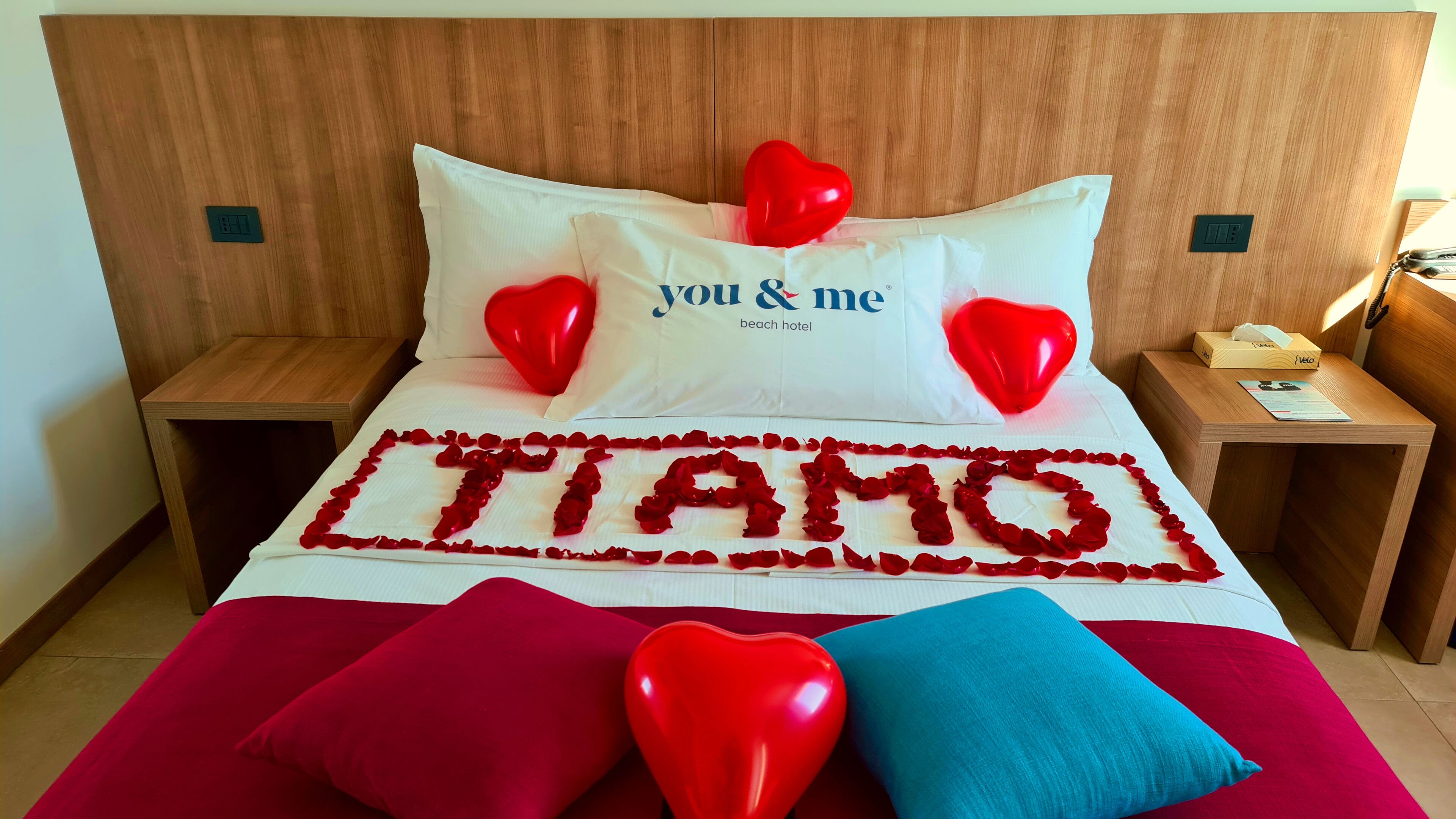 A hotel room with a bed, a bedside table, a nightstand, and a headboard.