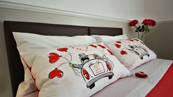 Ein Bett mit weißer Bettwäsche und zwei Kopfkissen mit Automotiv-Motiv.