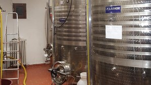 A clean, industrial-style room with stainless steel tanks, a ladder, and various hoses. - Agriturismo Podere Casa al Vento (Montepulciano)