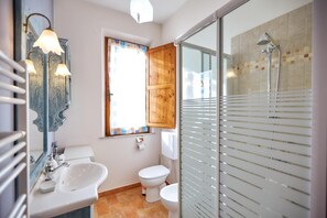 Een badkamer met een wastafel, toilet en douche.